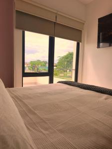 a bedroom with a bed with a large window at Puerto CARMA in Las Juntas