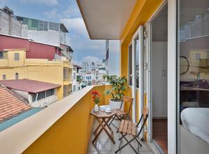 a balcony with a table and a view of a city at The Lake Silk Hotel & Travel in Hanoi