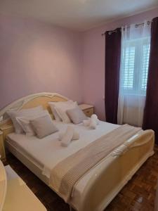a bedroom with a large white bed with white pillows at Nano Apartmani in Smokvica