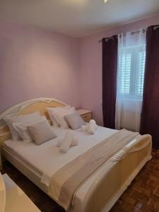 a bedroom with a large bed with white pillows at Nano Apartmani in Smokvica