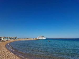 a cruise ship in the water next to a beach at Bosque Hotel in Hurghada