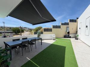 a patio with a table and chairs and grass at Vila Grafenola in Montargil