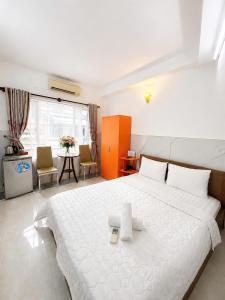 a bedroom with a large white bed and a table at Thanh Ha Guesthouse in Ho Chi Minh City