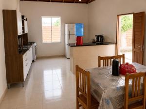 a kitchen with a table with chairs and a refrigerator at Villa Penelope in Paracuru