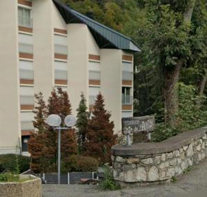 a building with a sign in front of a stone wall at Studio Barèges in Barèges