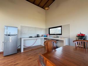 a kitchen with a table and a refrigerator at Bunut Sari Guesthouse in Ungasan