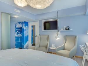 a blue bedroom with two chairs and a bed at Original Sokos Hotel Vaakuna Vaasa in Vaasa
