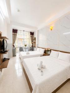 a hotel room with two beds and a television at Thanh Ha Guesthouse in Ho Chi Minh City +9 photos