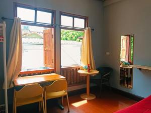 a room with a desk and a window and a table at Magic Garden Residence Bangkok in Bangkok