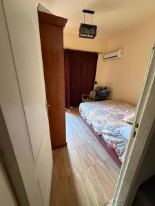 a small bedroom with a bed and a door at Oraby house in Al Ḩammām