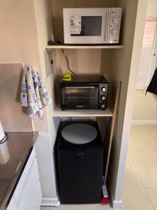 a small kitchen with a microwave and a trash can at Mendoza Centro Apartment in Mendoza