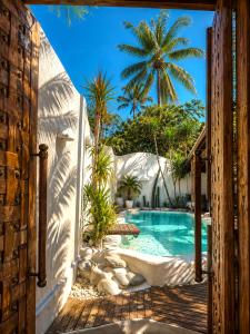 an entrance to a pool with a palm tree in the background at Kaleydo Villas in Gili Trawangan