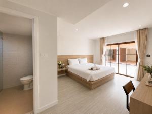 a bedroom with a bed and a toilet at Vanda Resort & Villa in Ban Thai Don (1)