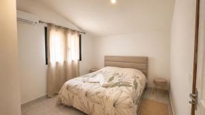 a bedroom with a bed in a white room at L' Aurore de Cassandre in Saint-Paul