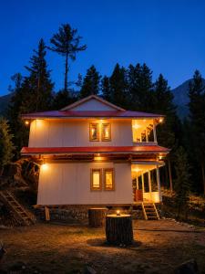 a house that is lit up at night at Fairy Meadows Comfort Lodges in Tato