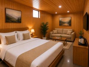 a bedroom with a large bed and a couch at Fairy Meadows Comfort Lodges in Tato