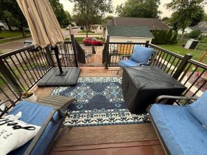a deck with two chairs and a rug on a balcony at Gorgeous Home in Prime Location in Sauk City