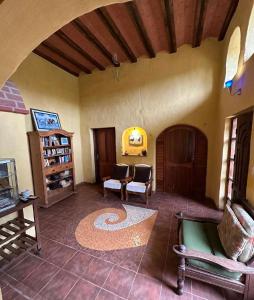 a living room with a couch and chairs in a room at Hotel el Amanecer in Samaipata