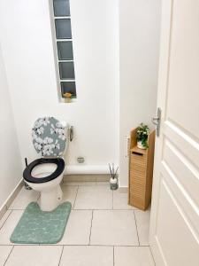 a bathroom with a toilet with a green rug at L' Aurore de Cassandre in Saint-Paul +6 photos