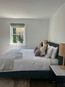 a bedroom with a bed with pillows and a window at The Berrima Vault House in Berrima