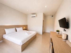 a bedroom with a bed and a flat screen tv at Vanda Resort & Villa in Ban Thai Don (1) +7 photos