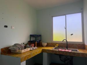 a kitchen counter with a sink and a window at Hostal mar de luna in Pedernales +5 photos