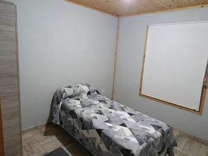 a bedroom with a bed with a quilt on it at Complejo El Mirador in Calingasta
