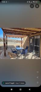 a patio with a table and chairs under a pavilion at Complejo El Mirador in Calingasta