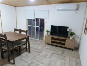 a living room with a table and a television at Complejo El Mirador in Calingasta
