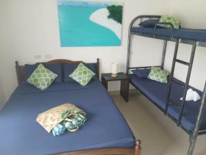 a bedroom with two bunk beds with blue sheets at HIGALA Resort in Panglao Island