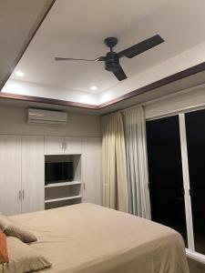 a bedroom with a ceiling fan and a bed at Apartamento Dulces Sueños in Bahia