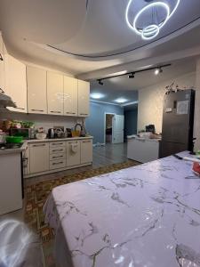a large kitchen with white cabinets and a large bed at Гостевой дом БАЯН in Cholpon-Ata