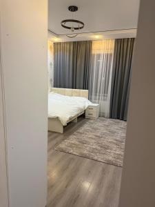 a bedroom with a bed and a rug at Гостевой дом БАЯН in Cholpon-Ata +4 photos