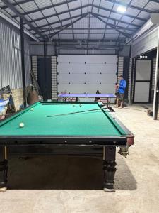 a man standing in a garage with a pool table at Гостевой дом БАЯН in Cholpon-Ata