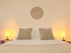 a white bed with two pillows and two lamps at Habitaciones Stonehaven Ruitoque in Piedecuesta