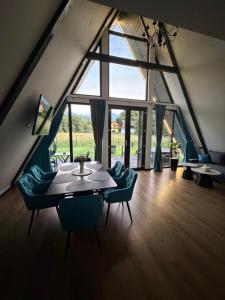a dining room with a table and chairs and a large window at Devi retreat in Arpaşu de Sus