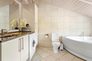 a bathroom with a tub and a toilet and a sink at LF750-Vestervig-Gunhildsvej-30 in Vestervig +16 photos