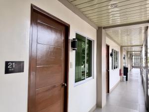 a wooden door in a hallway of a building at MF Suites in Manolo Fortich