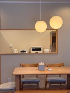 a dining room table with two chairs and two lights at Yamamori House in Hakuba