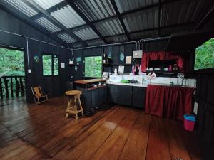 a black kitchen with a counter and a wooden floor at Cabaña blue jeans in San Ramón