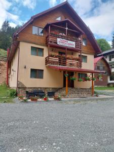 a building with a sign on the front of it at Cabana Diana&Larisa in Arieşeni