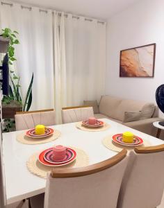 a dining room table with plates and cups on it at Auréa Residência - a 500 m da Praia in Cabedelo