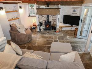 a living room with a couch and a fireplace at Lydgate Cottage in Eyam