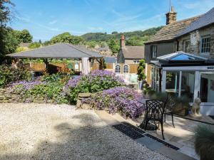 a garden with purple flowers and a house at Lydgate Cottage in Eyam