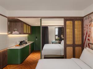 a hotel room with two beds and a kitchen at Elais by ARTOTEL in Medan