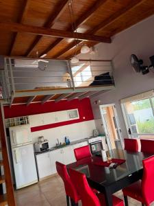 a kitchen with a dining room table and red chairs at Alborada in Gualeguaychú