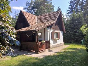 a small white house with a wooden gate at Planinska kucica Srce in Zlatibor