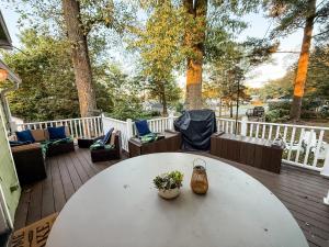 a white table and chairs on a wooden deck at The Float House at Buckeye Lake - Hot Tub - Patio - Privacy in Thornville
