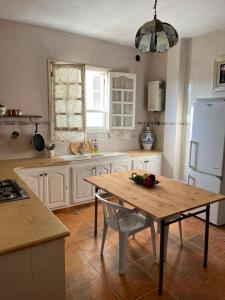 a kitchen with a wooden table and a refrigerator at Dar nawara in Kelibia
