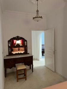 a room with a mirror on a table and a chair at Dar nawara in Kelibia